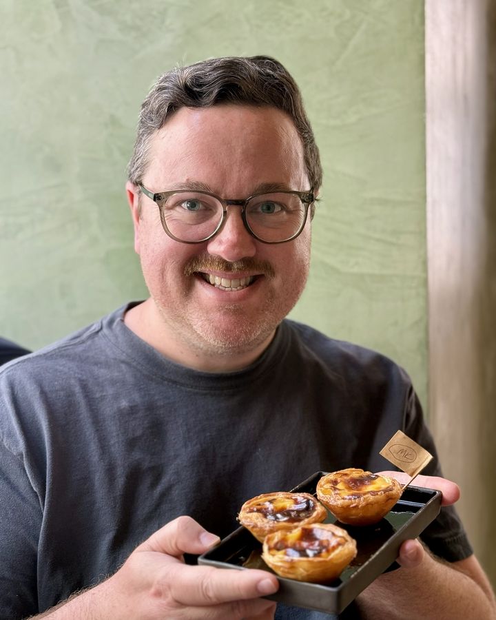 Michael holding a tray of pastel de nata in Portugal.